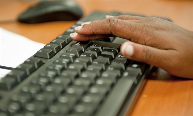 A hand typing on a keyboard, representing IT companies like QualityIP, a provider of IT Services for small business.